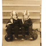 Twins in Striped Hats and Scarves and Wooly Snowsuits, in Wagon, Old RPPC